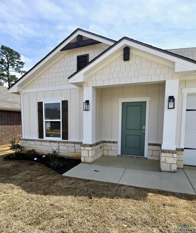 entrance to property with stone siding and board and batten siding