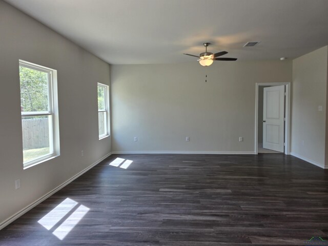 unfurnished room featuring dark wood-type flooring, baseboards, ceiling fan, and visible vents