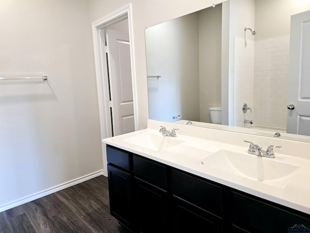 full bath featuring toilet, a sink, baseboards, and wood finished floors