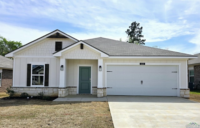 view of front of home with stone siding, an attached garage, board and batten siding, driveway, and a shingled roof