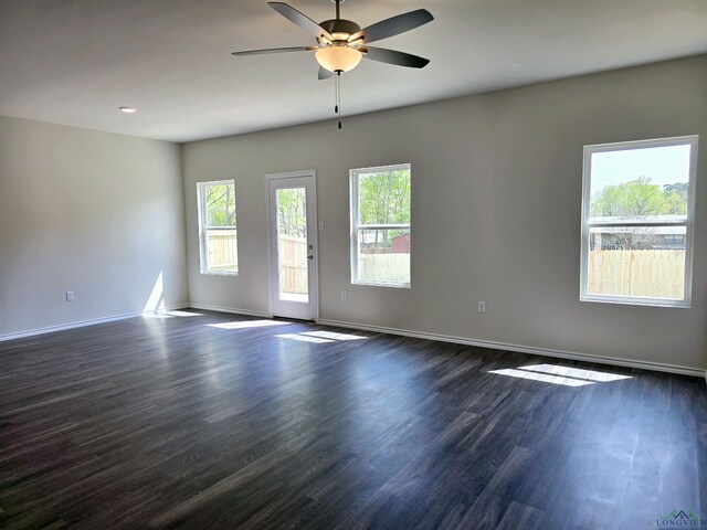 spare room featuring dark wood finished floors, baseboards, and a ceiling fan