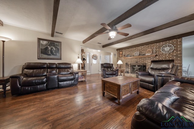 living room with beamed ceiling, ceiling fan, dark wood-type flooring, and a fireplace