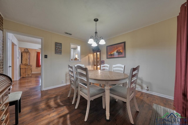 dining area featuring ornamental molding, dark hardwood / wood-style floors, and a chandelier