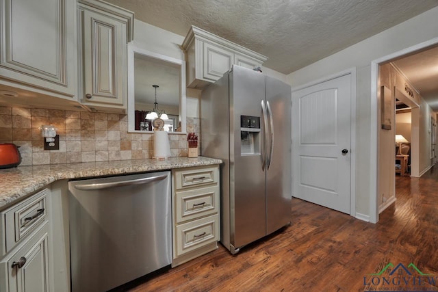 kitchen with dark hardwood / wood-style flooring, decorative backsplash, light stone countertops, and appliances with stainless steel finishes