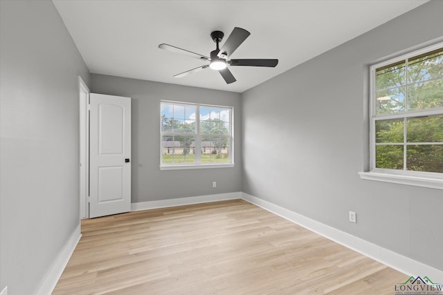empty room featuring light wood-style floors, ceiling fan, and a healthy amount of sunlight