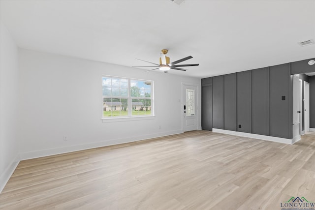 unfurnished living room with light wood finished floors, visible vents, a ceiling fan, and baseboards