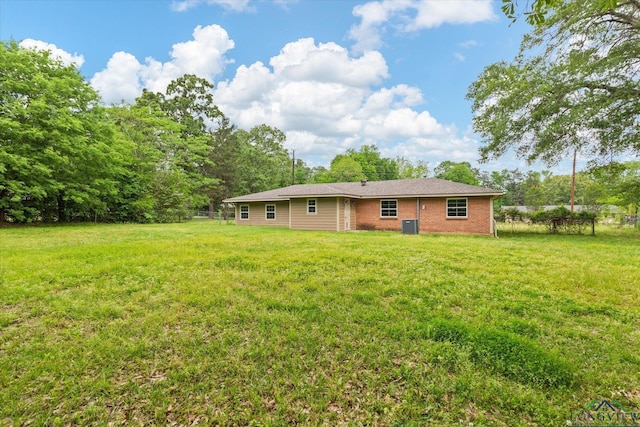 back of house with a lawn and brick siding