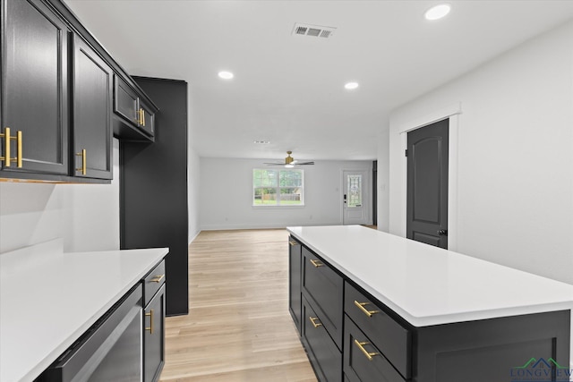 kitchen with light wood-type flooring, a ceiling fan, visible vents, and light countertops