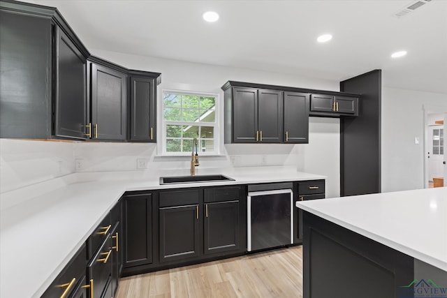 kitchen with light countertops, light wood-style floors, recessed lighting, and a sink
