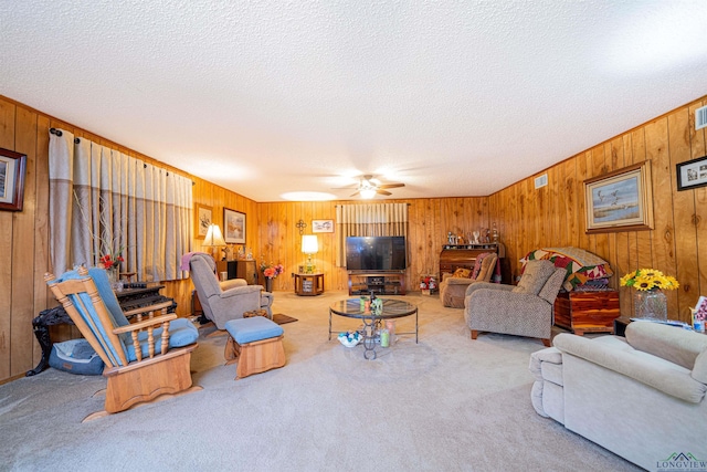 living room featuring ceiling fan, carpet, and a textured ceiling