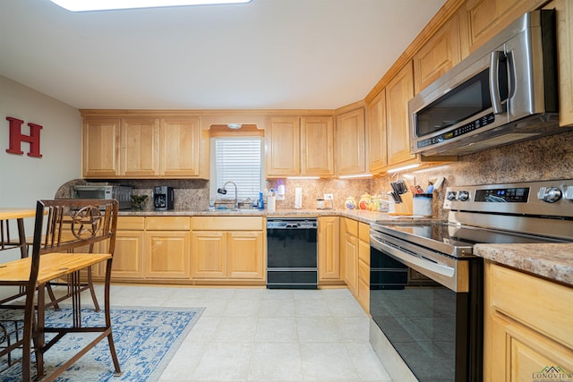 kitchen with backsplash, sink, light brown cabinetry, appliances with stainless steel finishes, and light stone counters