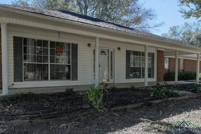 view of exterior entry with a porch