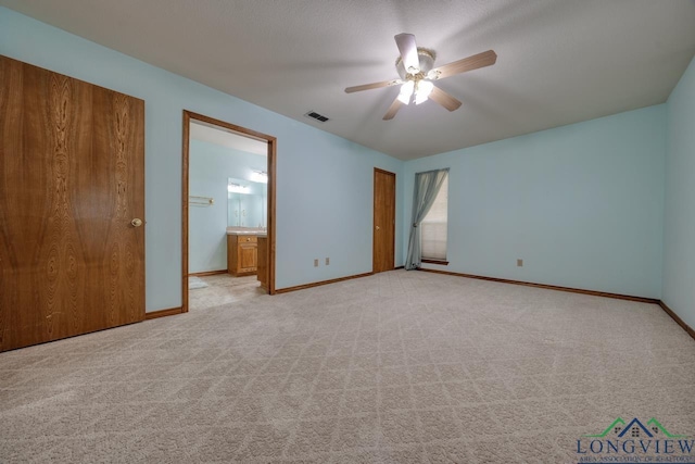 unfurnished bedroom featuring ceiling fan, ensuite bathroom, and light carpet