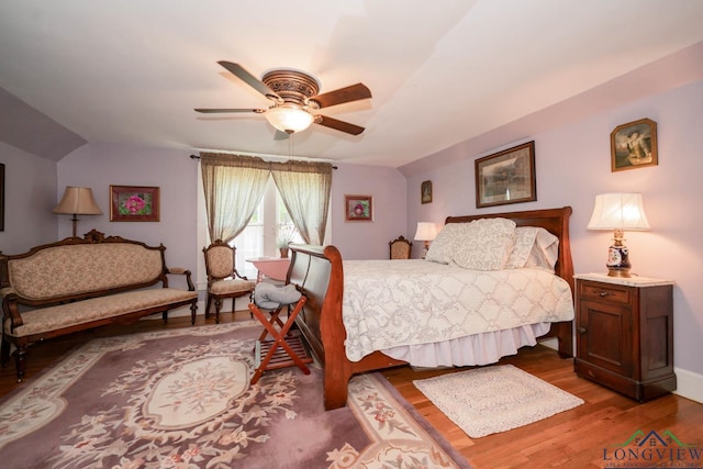 bedroom featuring hardwood / wood-style flooring, vaulted ceiling, and ceiling fan