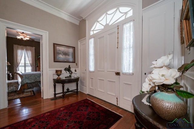 entrance foyer with ceiling fan, dark hardwood / wood-style floors, and ornamental molding