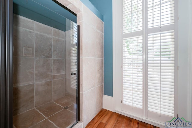 bathroom featuring wood-type flooring and an enclosed shower