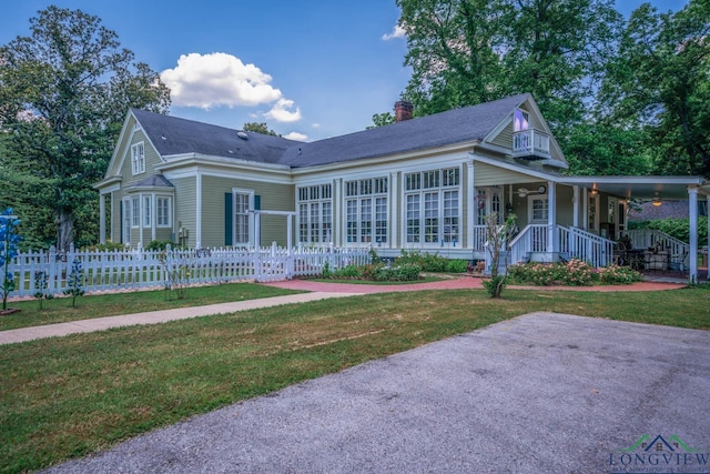 back of house with a lawn and covered porch