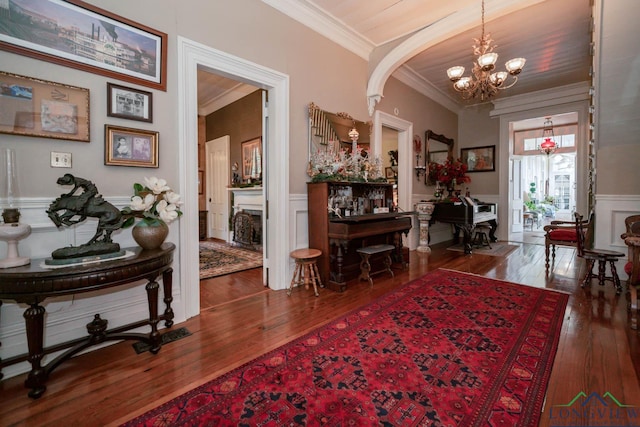 interior space with dark hardwood / wood-style flooring, ornamental molding, and a notable chandelier