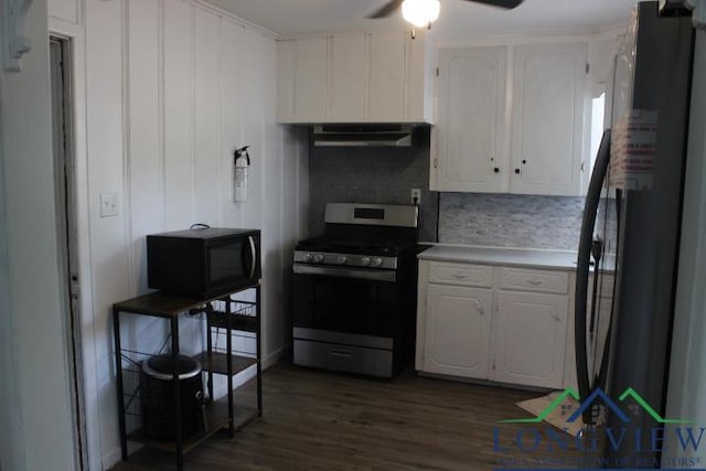 1212 N Edwards St, Gladewater, TX 75647 - kitchen with gas range, black microwave, range hood, freestanding refrigerator, and white cabinets