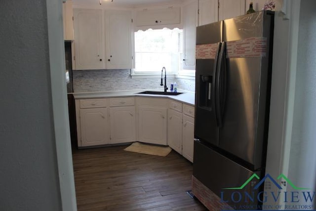 1212 N Edwards St, Gladewater, TX 75647 - kitchen with fridge with ice dispenser, a sink, white cabinets, dark wood finished floors, and light countertops