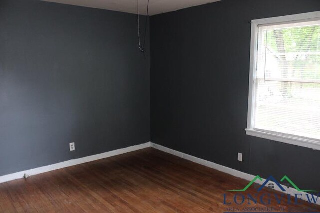 1212 N Edwards St, Gladewater, TX 75647 - spare room with dark wood finished floors, plenty of natural light, and baseboards
