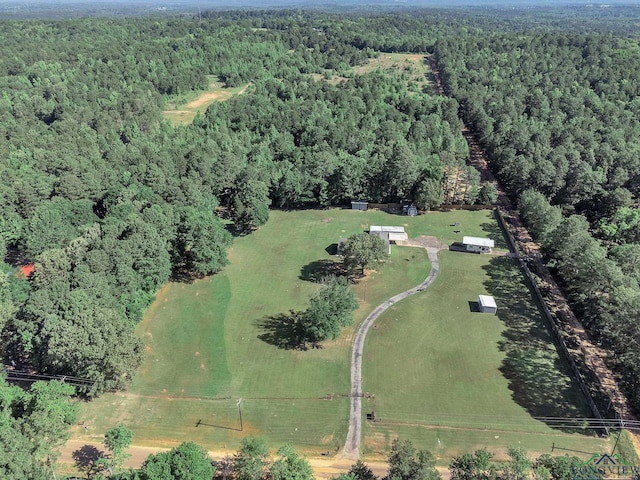 aerial view of property and surrounding area featuring a heavily wooded area
