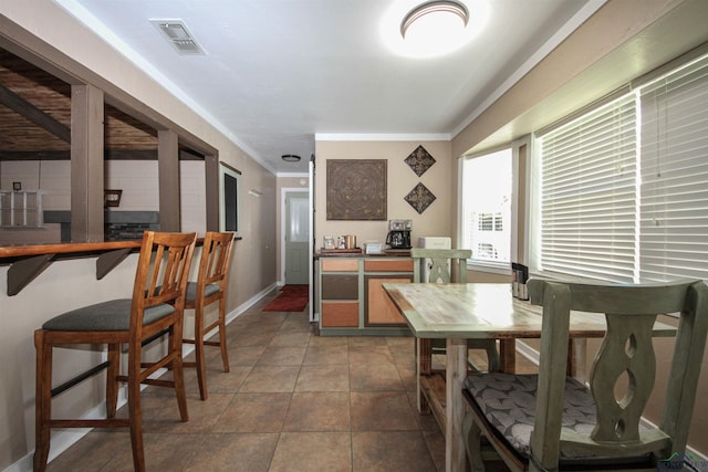 dining space with baseboards and crown molding