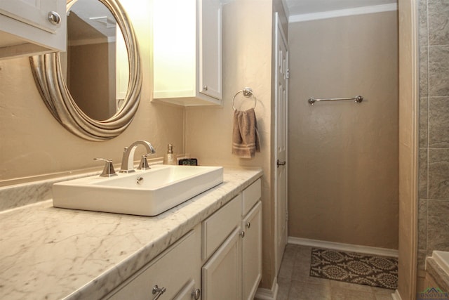 bathroom featuring ornamental molding, vanity, tile patterned floors, and baseboards