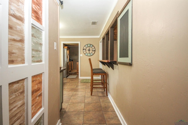 corridor featuring dark tile patterned flooring and baseboards