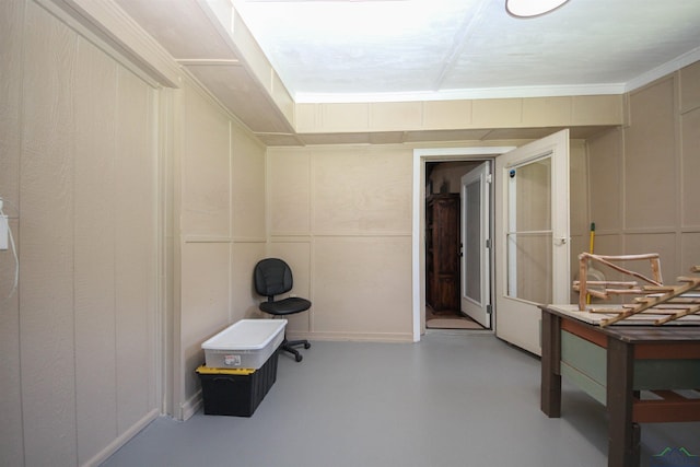 miscellaneous room with a decorative wall and concrete floors