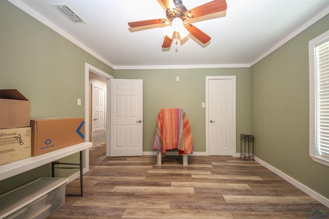 bedroom with crown molding, wood finished floors, baseboards, and a ceiling fan
