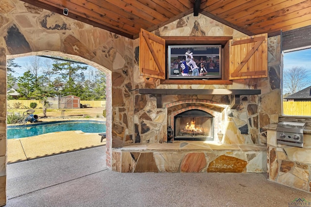 view of patio / terrace with a fenced in pool and an outdoor stone fireplace