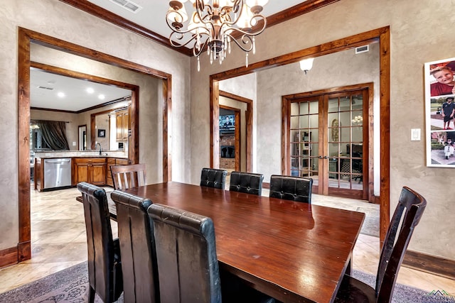 dining area with ornamental molding, a chandelier, and sink