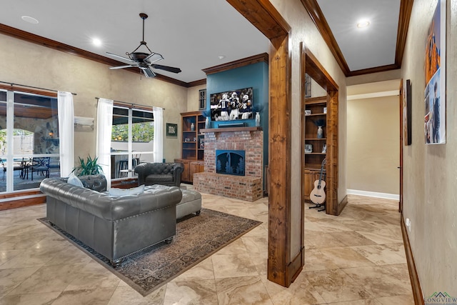 living room with a brick fireplace, crown molding, and ceiling fan