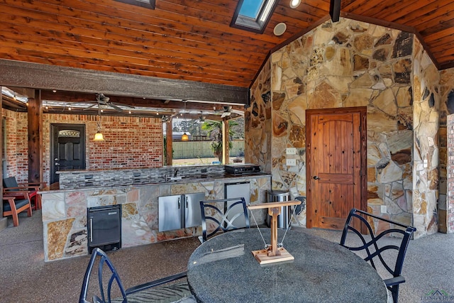 unfurnished dining area featuring ceiling fan, carpet, wood ceiling, and lofted ceiling with skylight