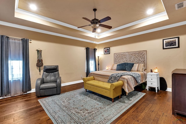 bedroom with ceiling fan, dark hardwood / wood-style flooring, crown molding, and a raised ceiling