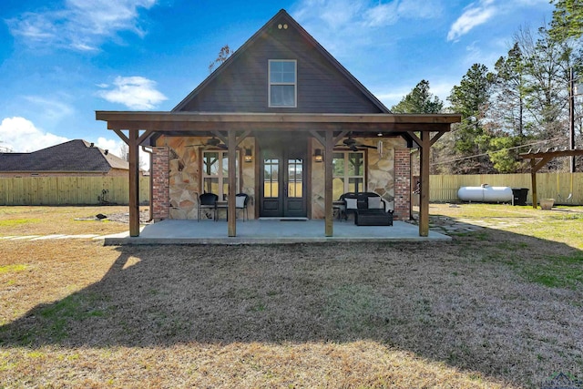 back of property featuring ceiling fan, french doors, a patio area, and a yard