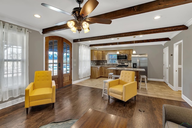 living room featuring ceiling fan, hardwood / wood-style floors, beam ceiling, and french doors