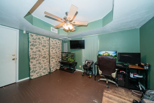 office with wood finished floors, baseboards, visible vents, ceiling fan, and a raised ceiling