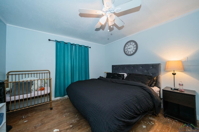 bedroom featuring ceiling fan, lofted ceiling, wood finished floors, and ornamental molding