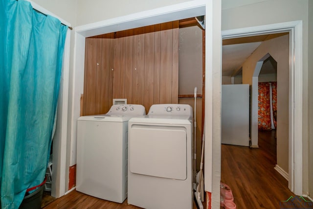 washroom with wood finished floors and washing machine and dryer