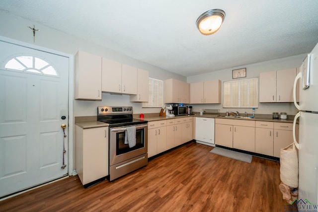 kitchen featuring dark wood finished floors, white appliances, a textured ceiling, and a sink