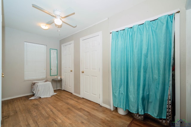 unfurnished bedroom featuring a ceiling fan, wood finished floors, and baseboards