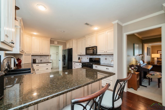 kitchen featuring black appliances, kitchen peninsula, and sink