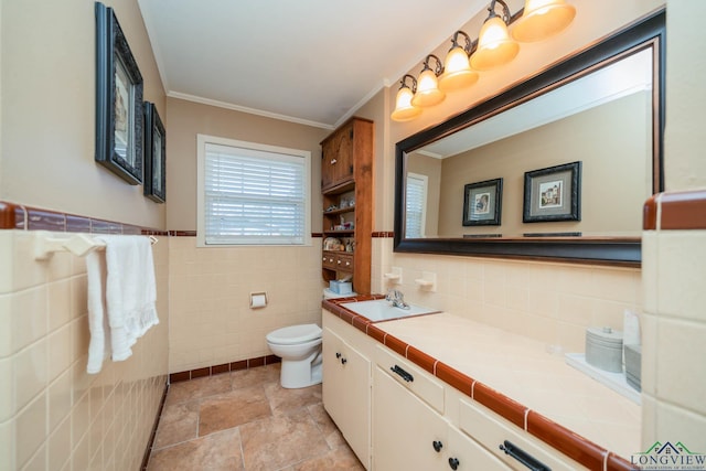 bathroom with vanity, toilet, crown molding, and tile walls