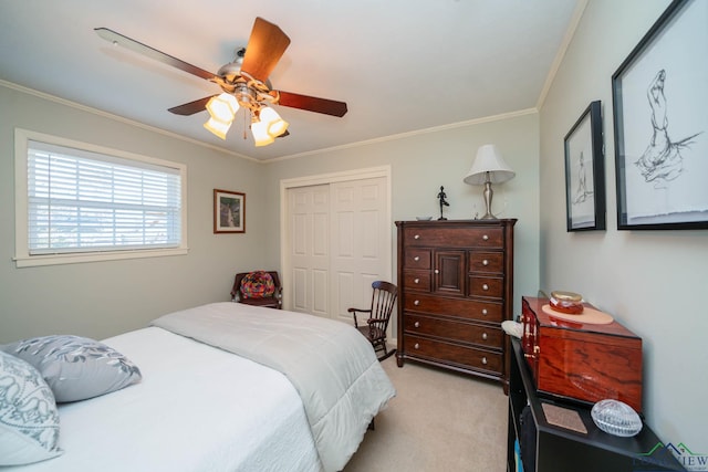 bedroom with ceiling fan, a closet, light colored carpet, and crown molding