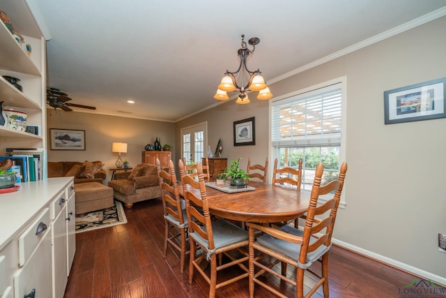 dining room with dark wood-type flooring, ceiling fan with notable chandelier, and ornamental molding