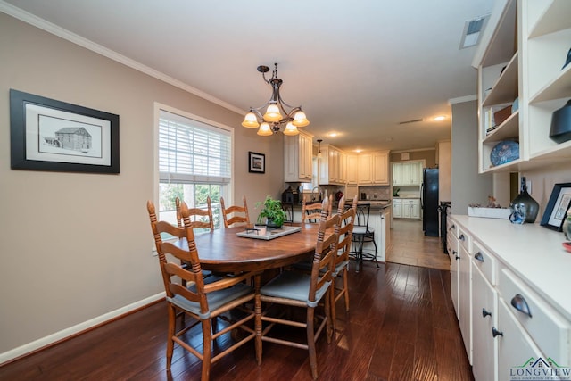 dining area featuring crown molding, dark hardwood / wood-style floors, and a notable chandelier