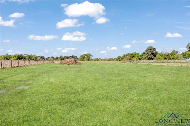 view of yard featuring fence and a rural view