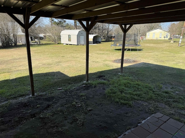 view of yard featuring a storage unit and a trampoline